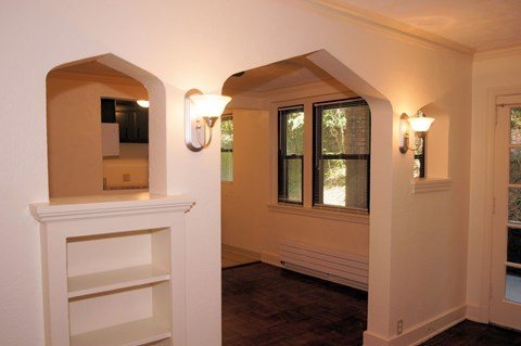 the living room of a house with white walls and a window
