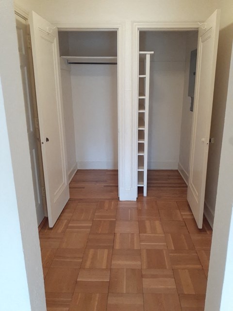 a room with a staircase and a closet and a wood floor