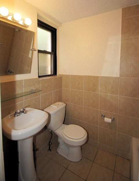a bathroom with a toilet sink and a mirror