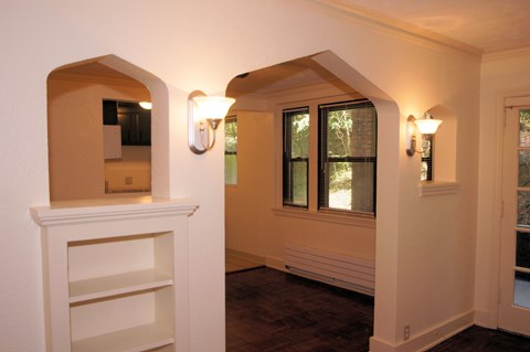 the living room of a house with white walls and a window