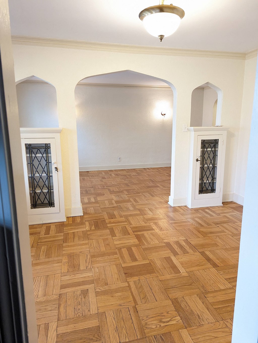 an empty living room with a wooden floor and a door
