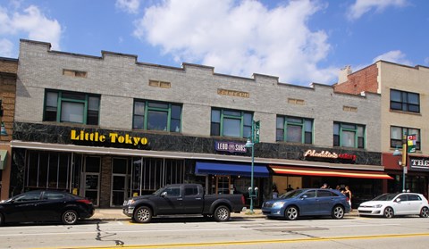 a brick building with a little restaurant on the side of a street