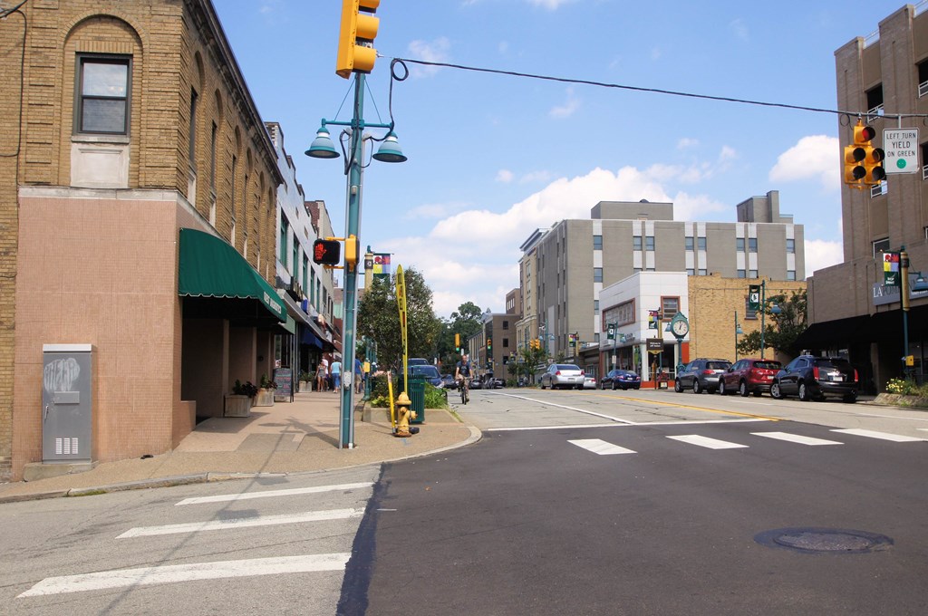 a city street with a yellow traffic light and a building on the corner