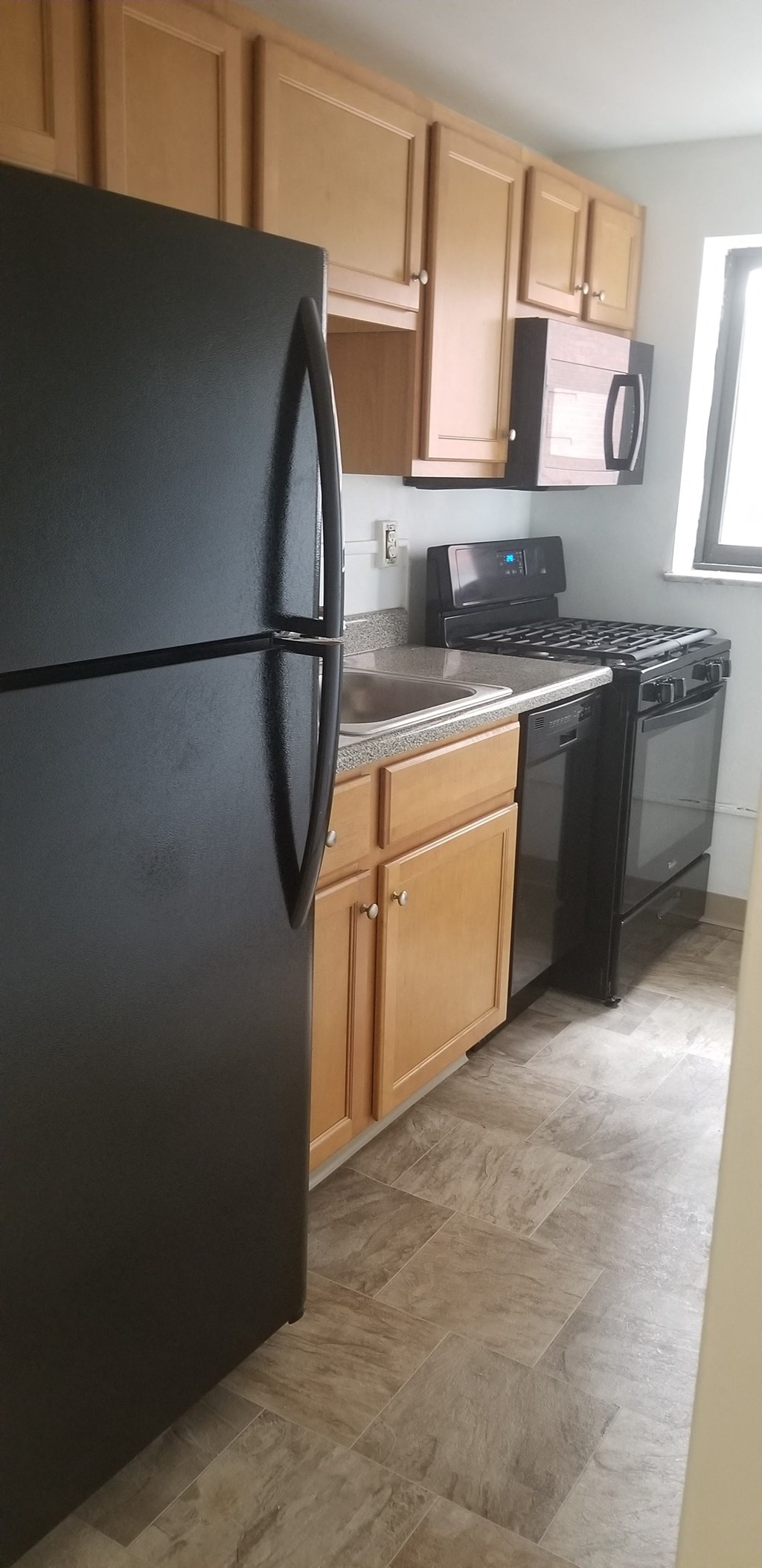a kitchen with black appliances and wooden cabinets