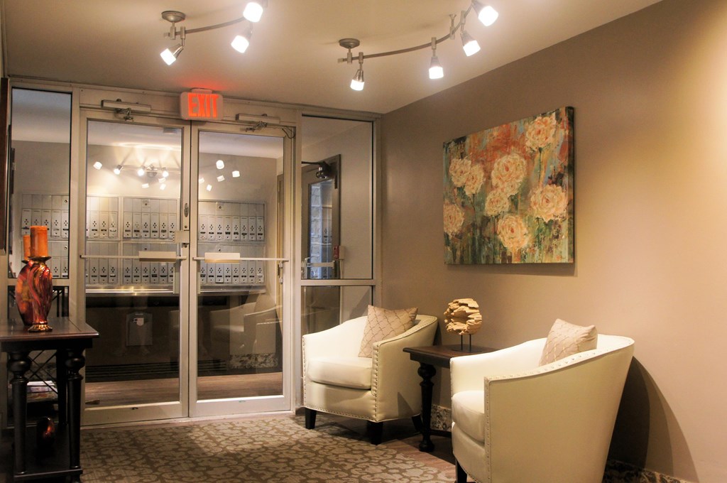a living room with white furniture and a painting on the wall