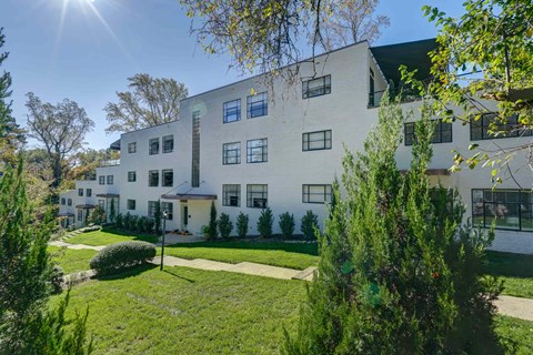 A white building with a green lawn in front.