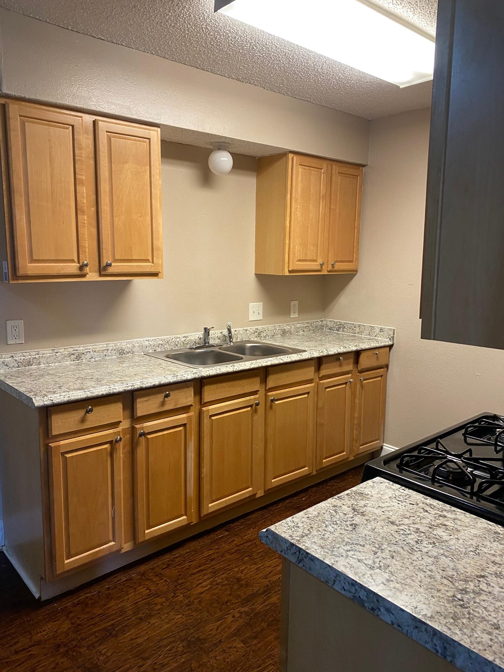 A kitchen with wooden cabinets and a granite countertop.