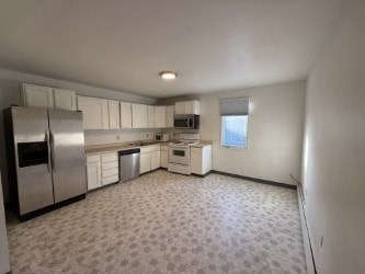 A kitchen with white cabinets and appliances.