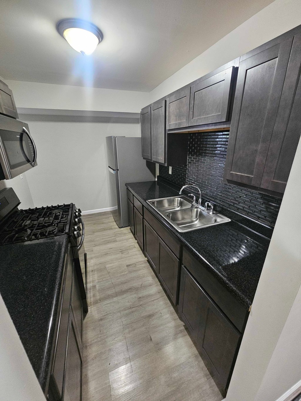 A kitchen with black cabinets and a black counter top.
