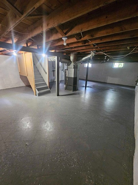 A spacious basement with a staircase and a window.