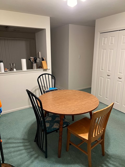 A dining room with a table and chairs.