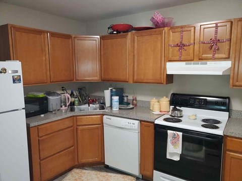 A kitchen with wooden cabinets and a black oven.
