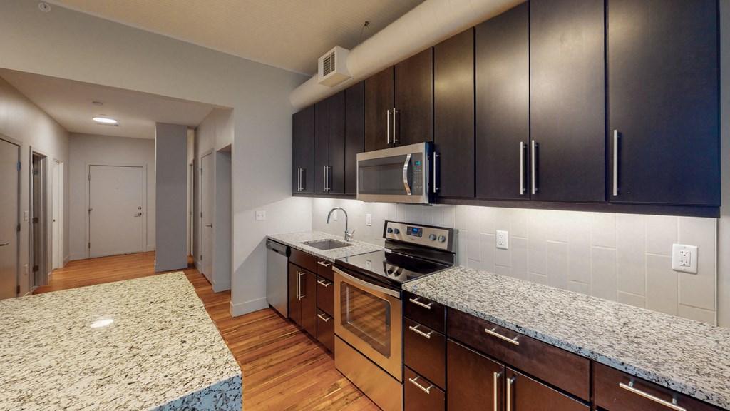 a kitchen with granite counter tops and wooden cabinets