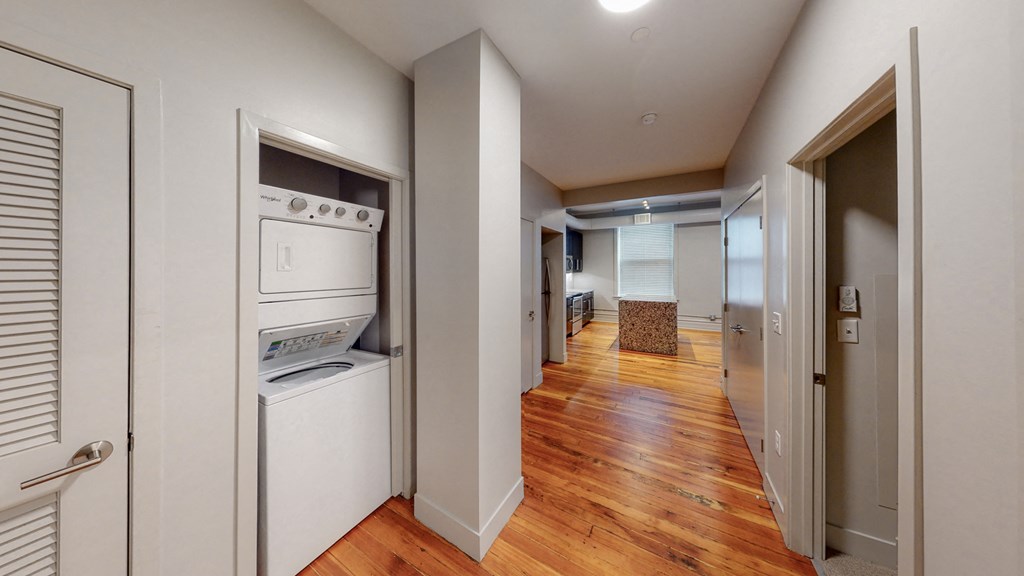 a laundry room with a washer and dryer and a hallway with a door