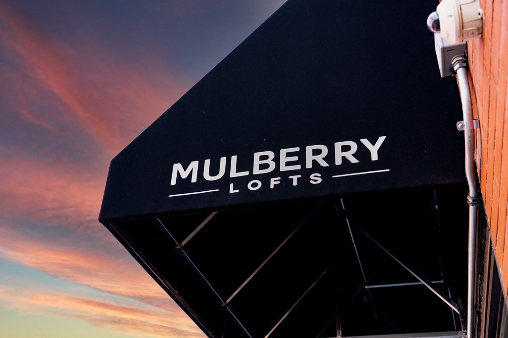 a sign on the side of a building at sunset