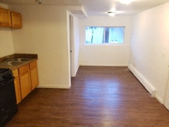 A kitchen with wooden floors and white walls.