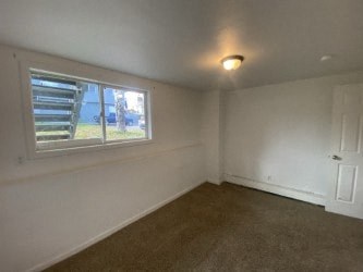 A room with a window and carpeted floor.