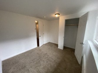 A room with a carpeted floor and white walls.