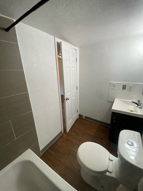 A white toilet sits in a bathroom next to a sink and a bathtub.