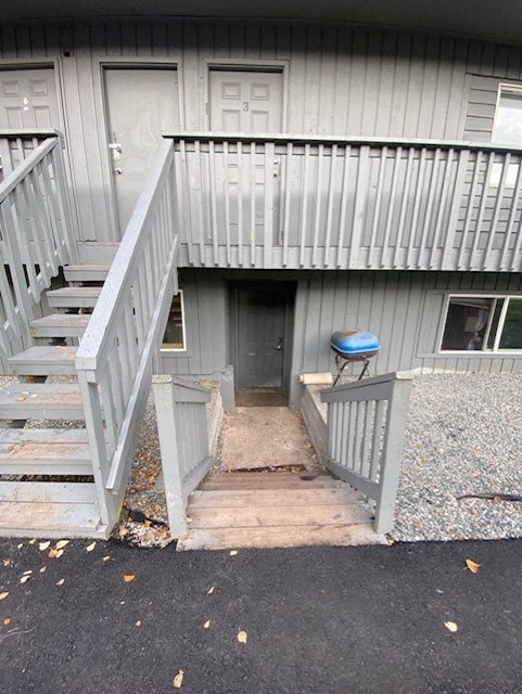 A grey house with a staircase leading to a door.
