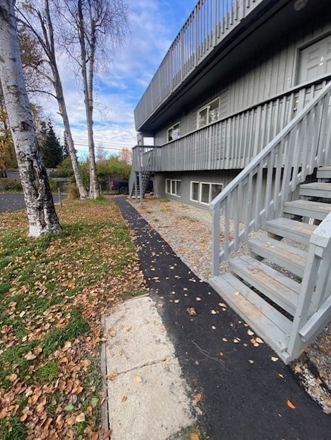 A concrete staircase with a metal railing leads up to a building.