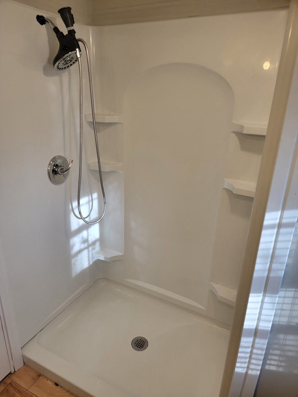 the shower in the tiny bathroom is clean and ready for us to use