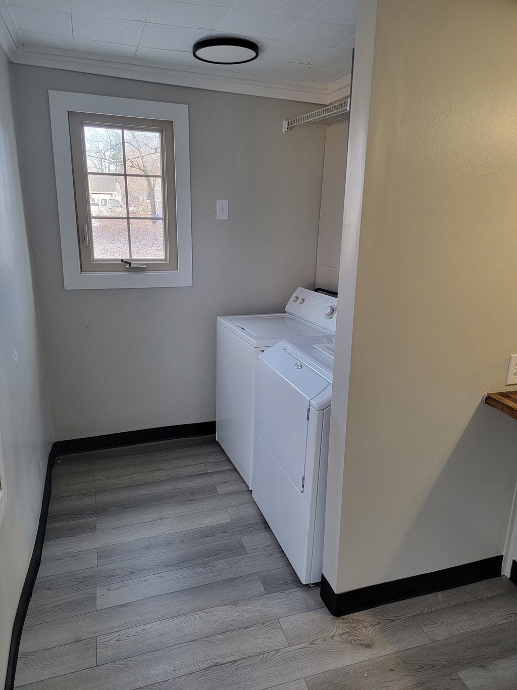 an empty laundry room with two washes and a window