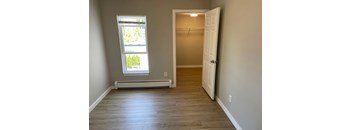 an empty room with a closet and a window