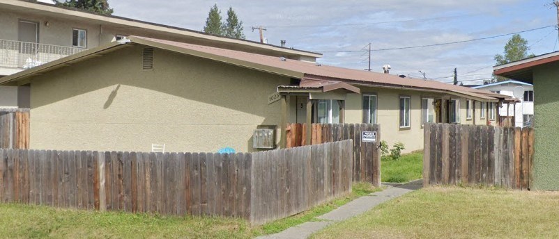 a house with a wooden fence in front of it