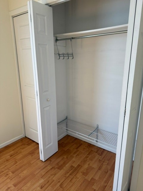 A white closet with a shelf and a door.
