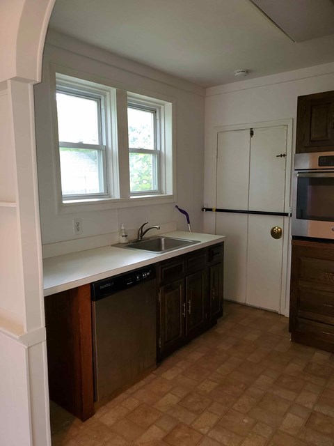 A kitchen with brown cabinets and a white sink.