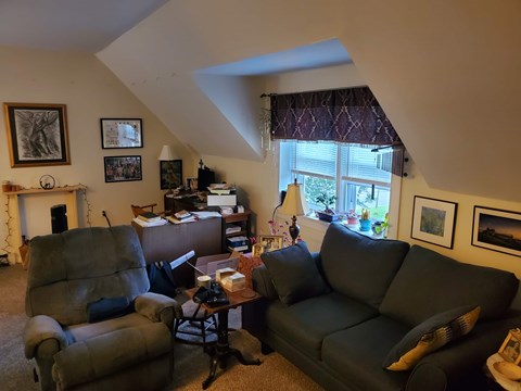 A living room with a grey couch and a brown leather chair.