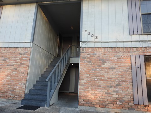 the stairs to the second floor of a brick building
