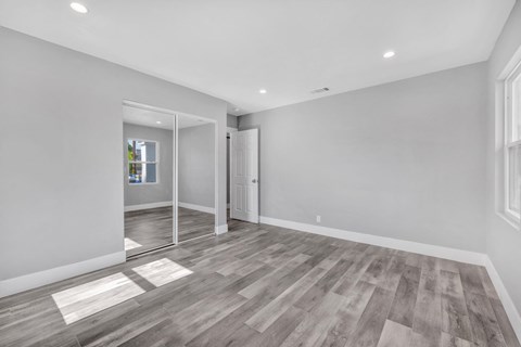 the living room of a new home with white walls and wood floors