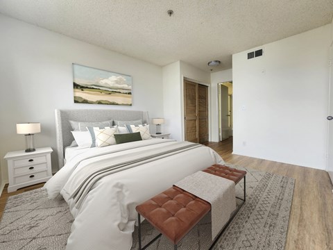 A bedroom with a large bed and a painting on the wall.