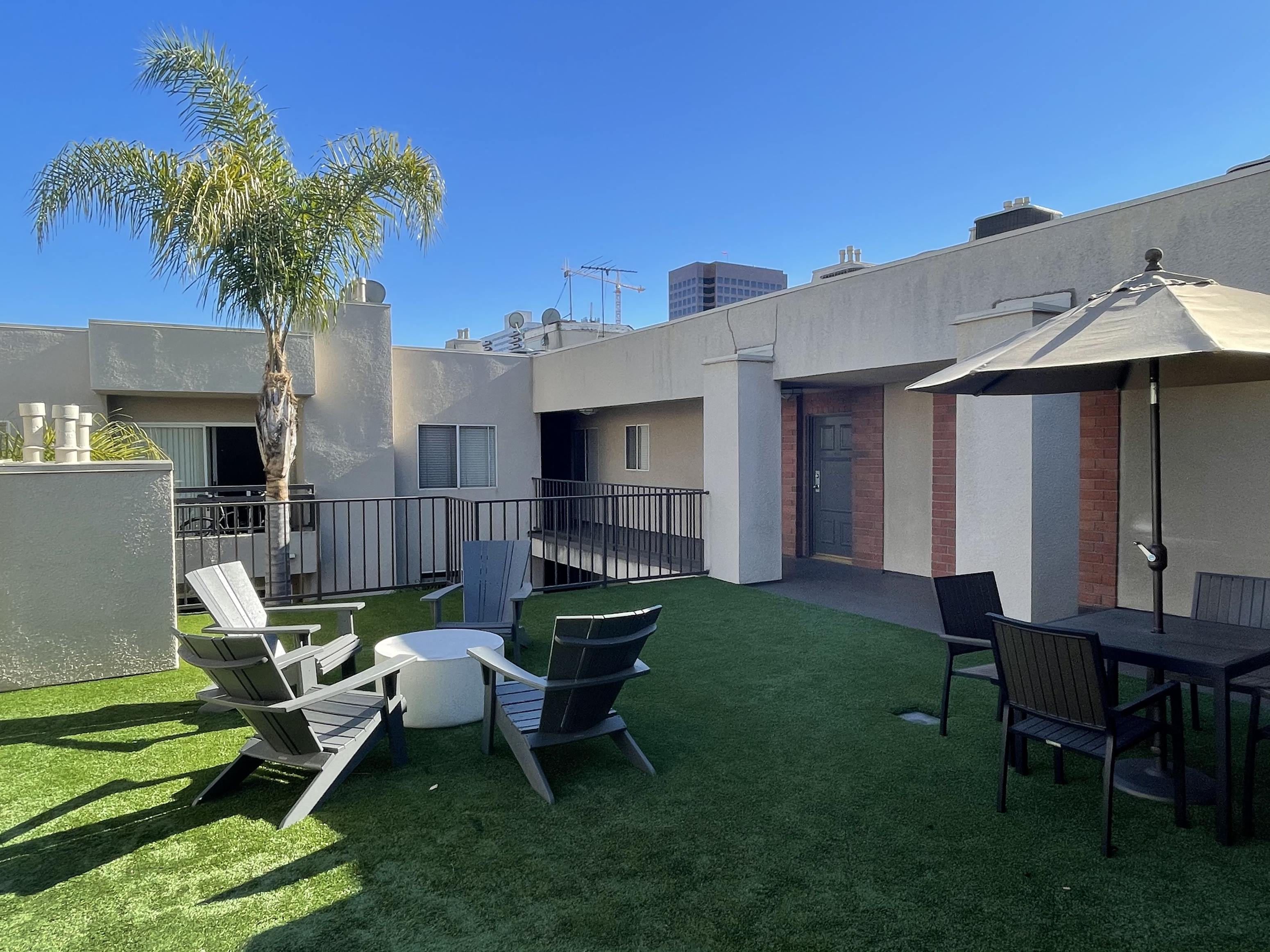 a patio with a table and chairs and a palm tree