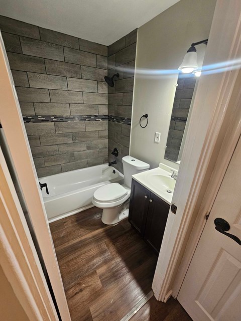 A bathroom with a toilet, sink, and tub.
