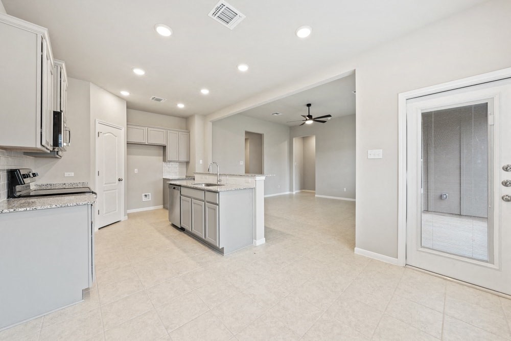 an open kitchen and living room with a door to a closet
