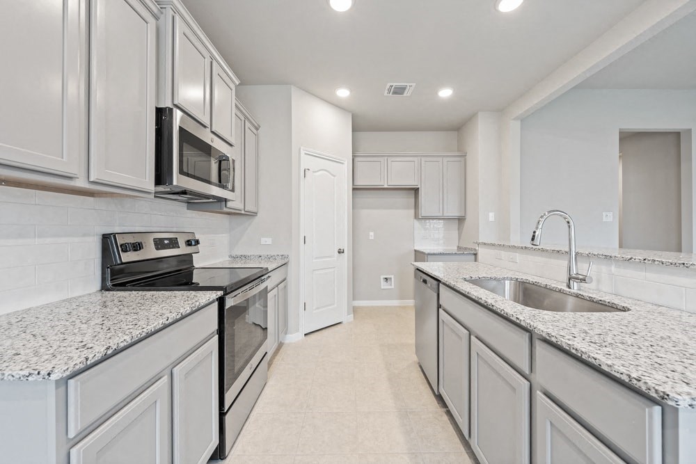 a large kitchen with marble counter tops and white cabinets