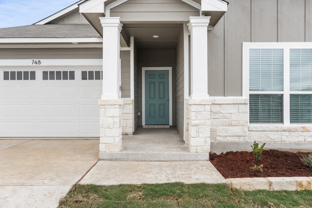 a house with a blue door and a sidewalk in front of it
