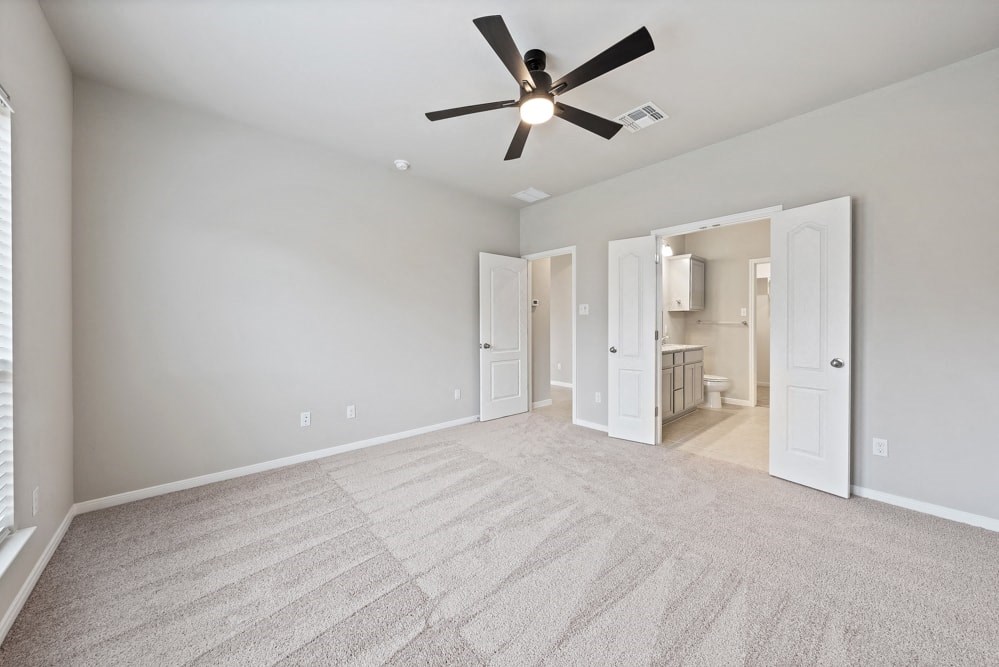 an empty living room with a ceiling fan