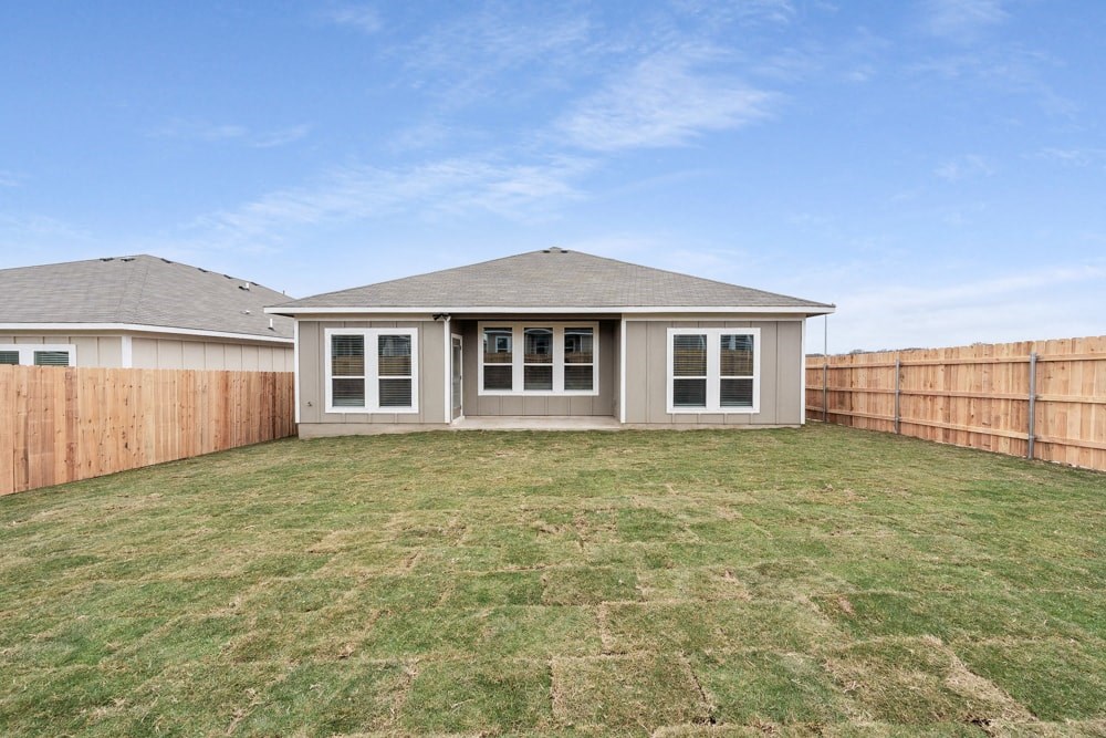 a backyard with a house and a fence