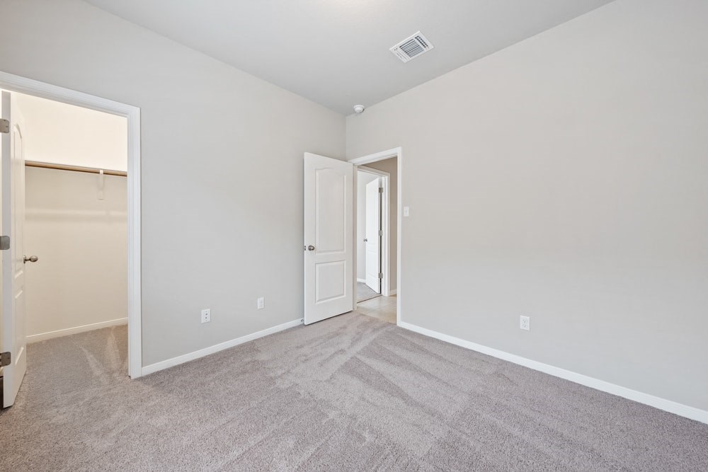 a bedroom with carpet and a door to a closet