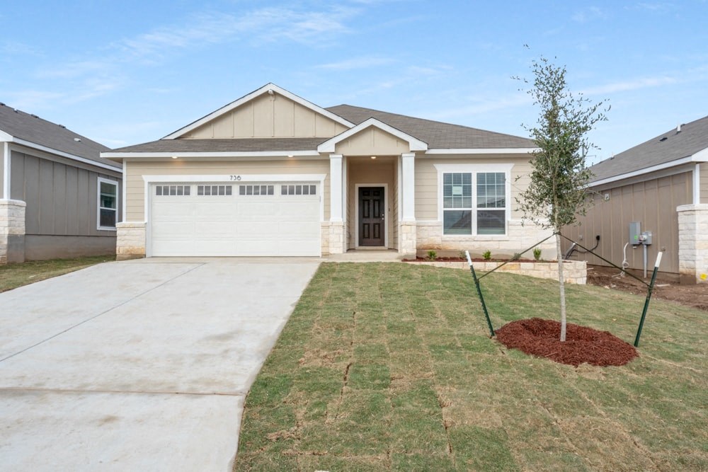 a home with a white garage door and a lawn