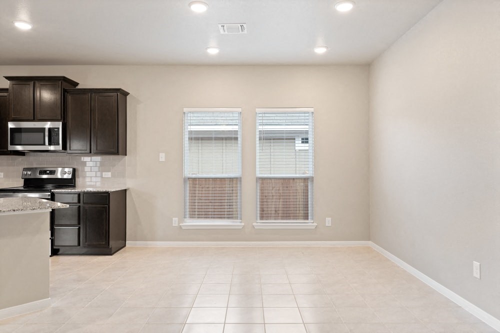 an empty kitchen with black appliances and a window