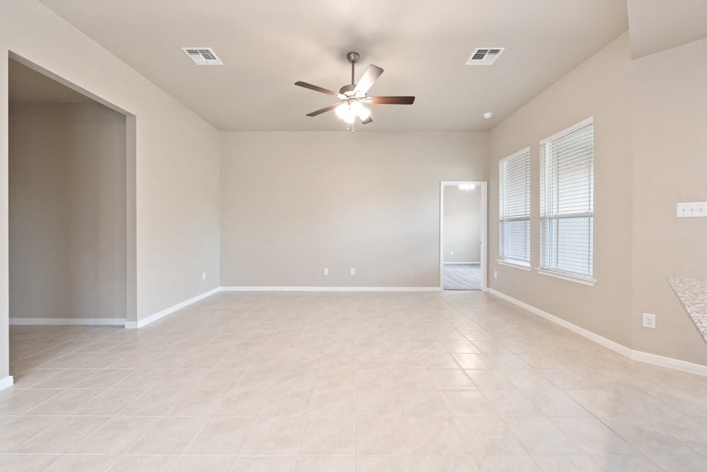 an empty living room with a ceiling fan