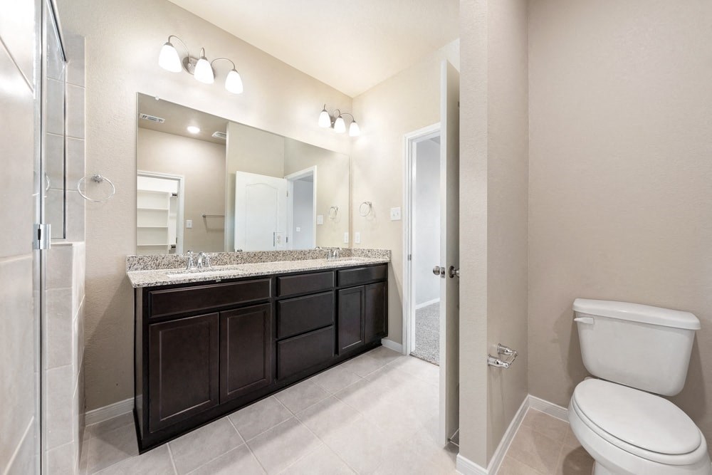 a bathroom with a toilet and a large mirror