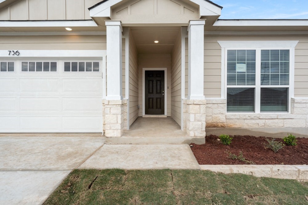 a home with a white garage door and a driveway