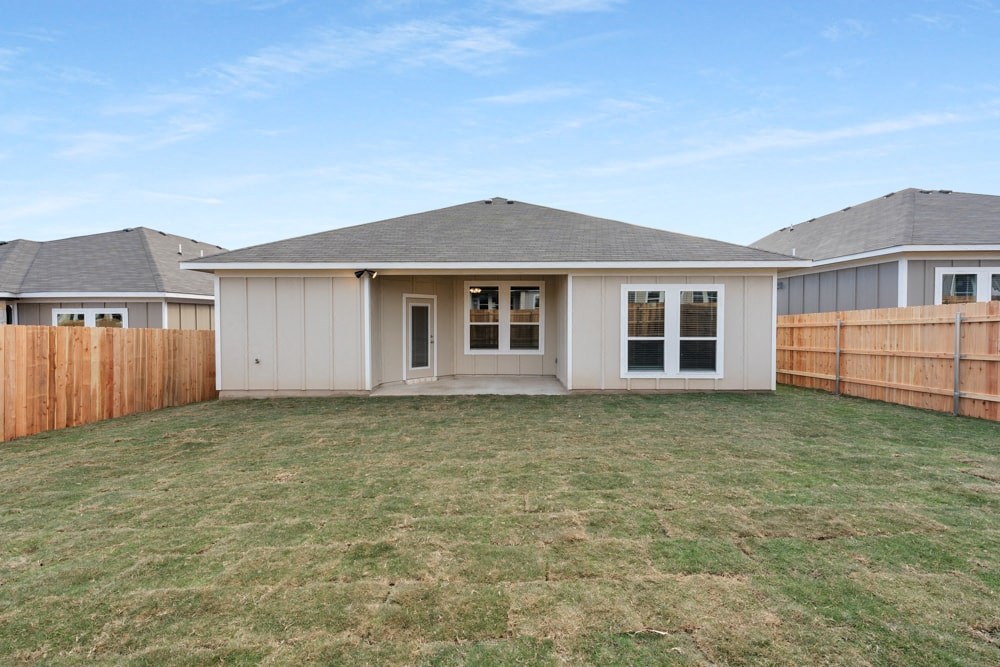 the backyard of a house with a yard and a fence