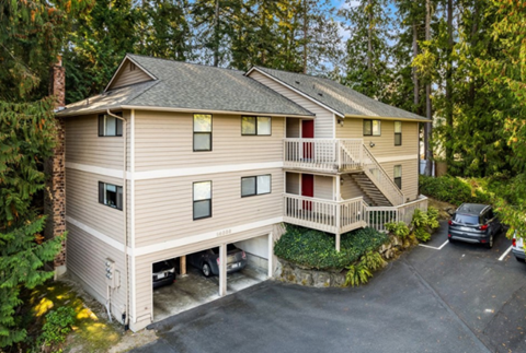 an aerial view of a house with a parking lot